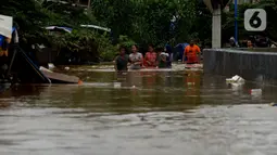 Warga melewati banjir yang menggenangi Jalan Jatinegara Barat, Jakarta, Kamis (2/1/2020). Hujan yang terjadi kemarin malam membuat Kali Ciliwung meluap ke jalan. (merdeka.com/Imam Buhori)