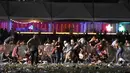 Sejumlah pengunjung berlindung saat festival musik Route 91 Harvest country setelah aksi penembakan di Las Vegas, Nevada (1/10). Pelaku penembakan disebut menembak seorang petugas keamanan dan polisi setempat. (David Becker/Getty Images/AFP)