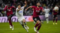Penyerang Real Madrid Marco Asensio berebut bola dengan bek Valencia Omar Alderete (kanan) pada laga pekan ke-20 La Liga Spanyol di Santiago Bernabeu Valencia, Minggu dini hari WIB (9/1/2022). Real Madrid menang meyakinkan 4-1 atas Valencia. (AP Photo/Bernat Armangue)