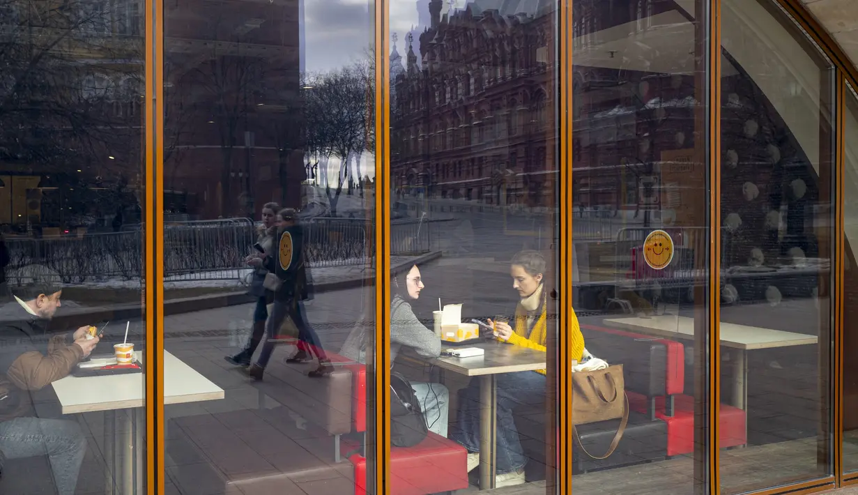 Tembok Kremlin dan Museum Sejarah tercermin di jendela restoran McDonald's pada hari kerja terakhirnya di Manezhnaya Square di Moskow, Senin (14/3/2022). Gerai makanan cepat saji McDonald’s resmi menutup 850 gerainya yang beroperasi di Rusia pada 14 Maret 2022. (AP Photo)