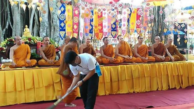 Seorang petugas kebersihan menyapu karpet di hadapan para bhiksu yang bermeditasi di Candi Mendut. (foto: Liputan6.com/danu kisworo/edhie prayitno ige)