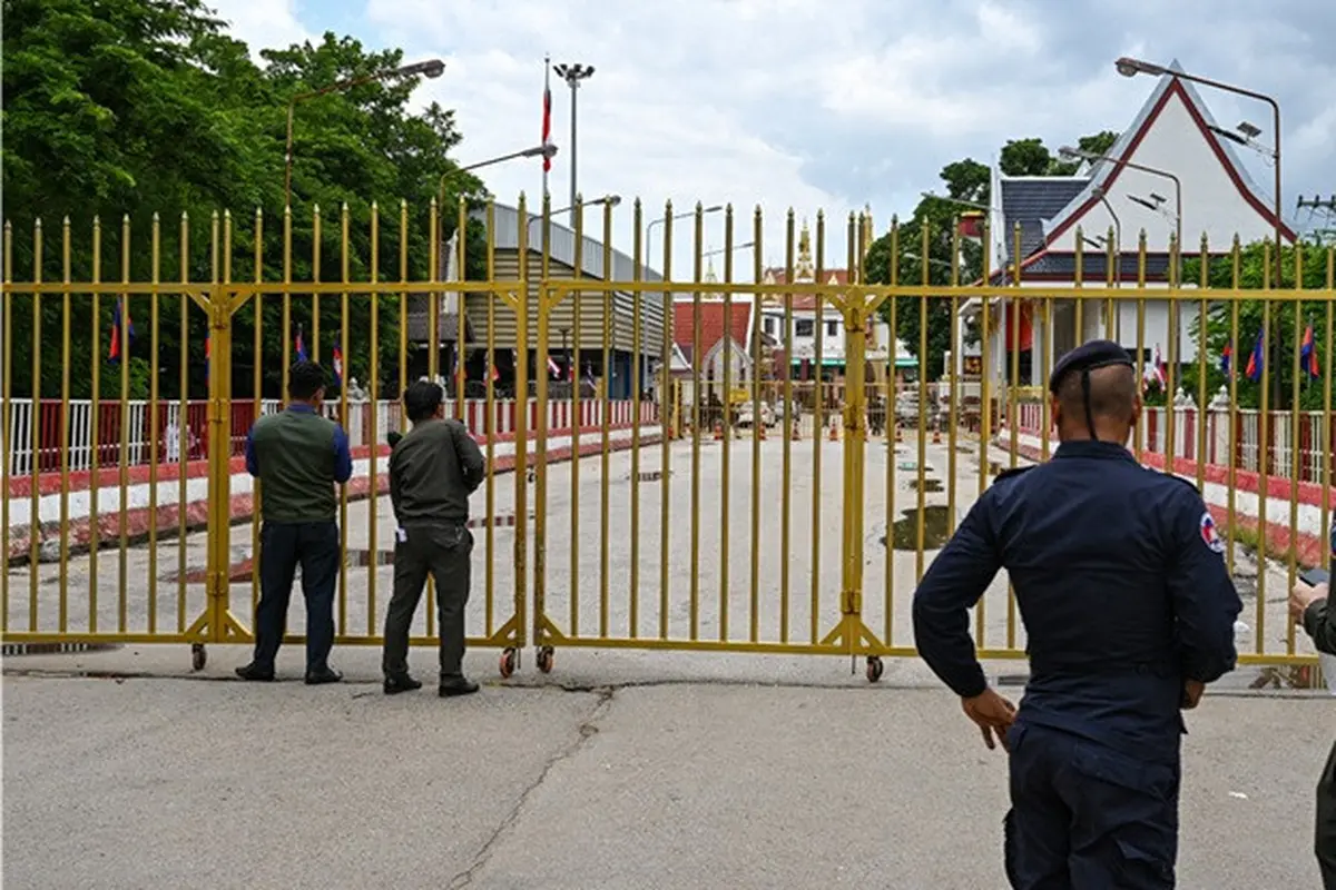 Petugas kepolisian Kamboja berjaga di depan gerbang yang ditutup di pos pemeriksaan perbatasan internasional Poipet, yang menghubungkan Kamboja dan Thailand, di Provinsi Banteay Meanchey, pada 24 Juni 2025.