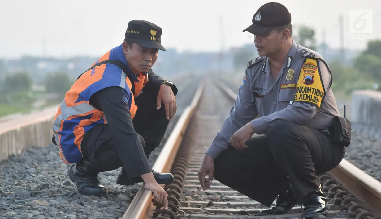 Petugas gabungan dari Polsuska dan Babinkamtibmas Kemijen Semarang  baut rel api di Jalur Kemijen, Minggu (3/6). Pemeriksaan dilakukan secara ketat dan berkala untuk keamanan jalur kereta api selama arus mudik 2018. (Liputan6.com/Gholib)