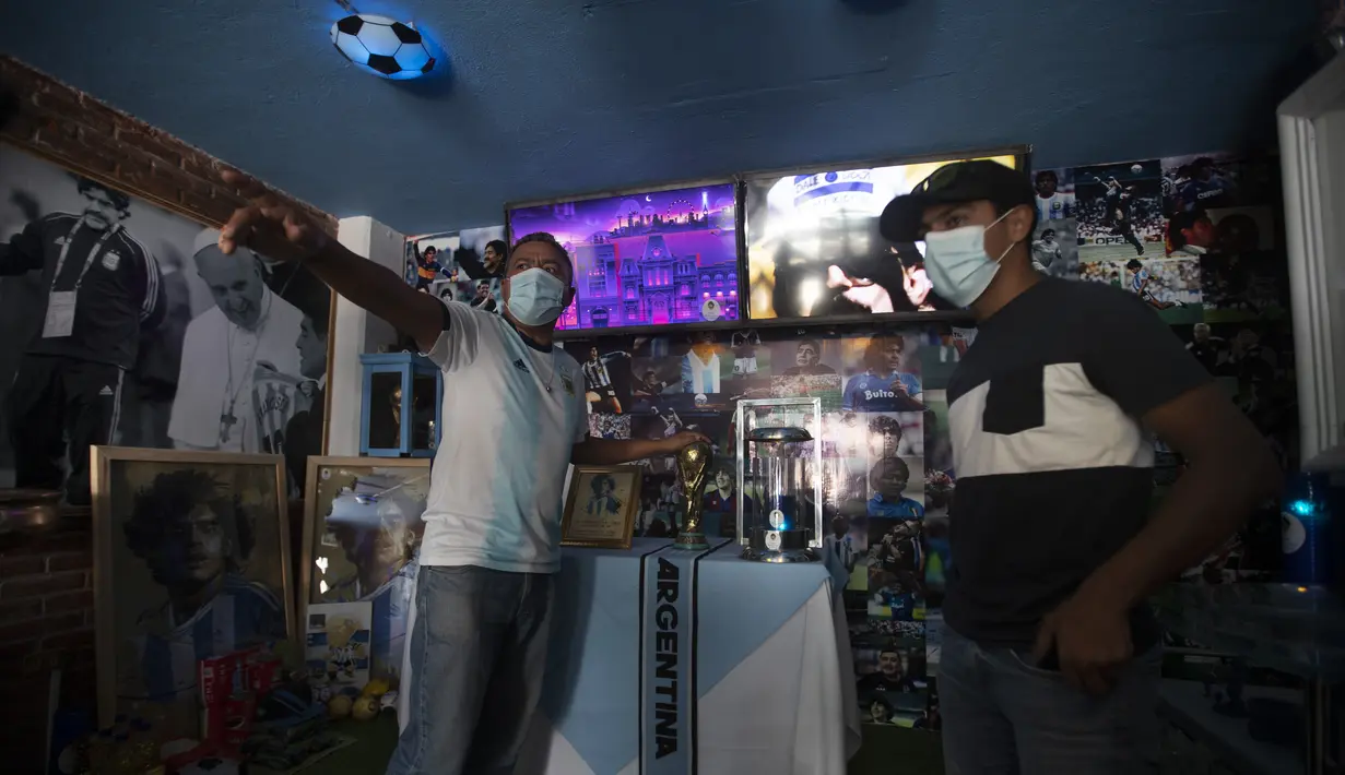 Pendiri Gereja Maradona Marcelo Buchet (kiri) berbicara dengan Raul Martinez selama kunjungan ke gereja di San Andres Cholula, negara bagian Puebla, Meksiko, Minggu (18/7/2021). Beberapa penggemar Diego Maradona berkunjung ke gereja ini. (AP Photo/Marco Ugarte)