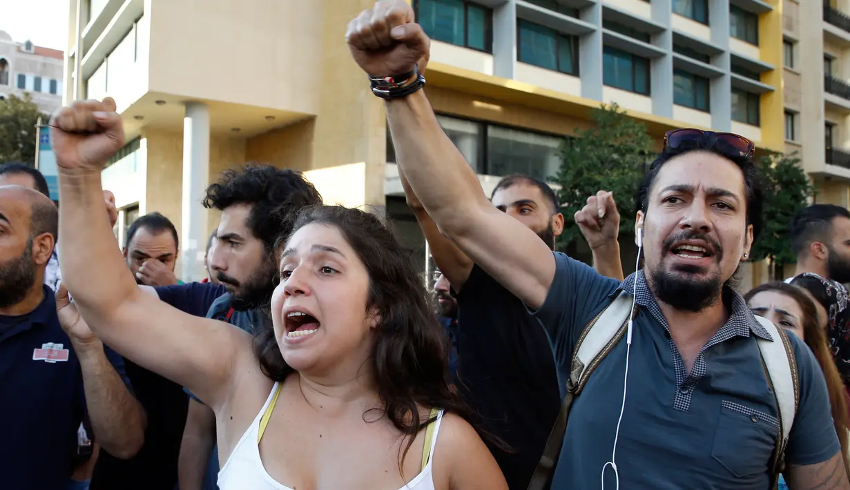 Pengunjuk rasa meneriakkan "Revolusi" setelah PM Lebanon Saad Hariri mengumumkan pengunduran dirinya, di depan istana pemerintahan di Beirut, Selasa (29/10/2019). Hal itu Saad Hariri lakukan untuk memenuhi salah satu tuntutan utama gerakan unjuk rasa yang memanas di negara itu. (AP/Bilal Hussein)