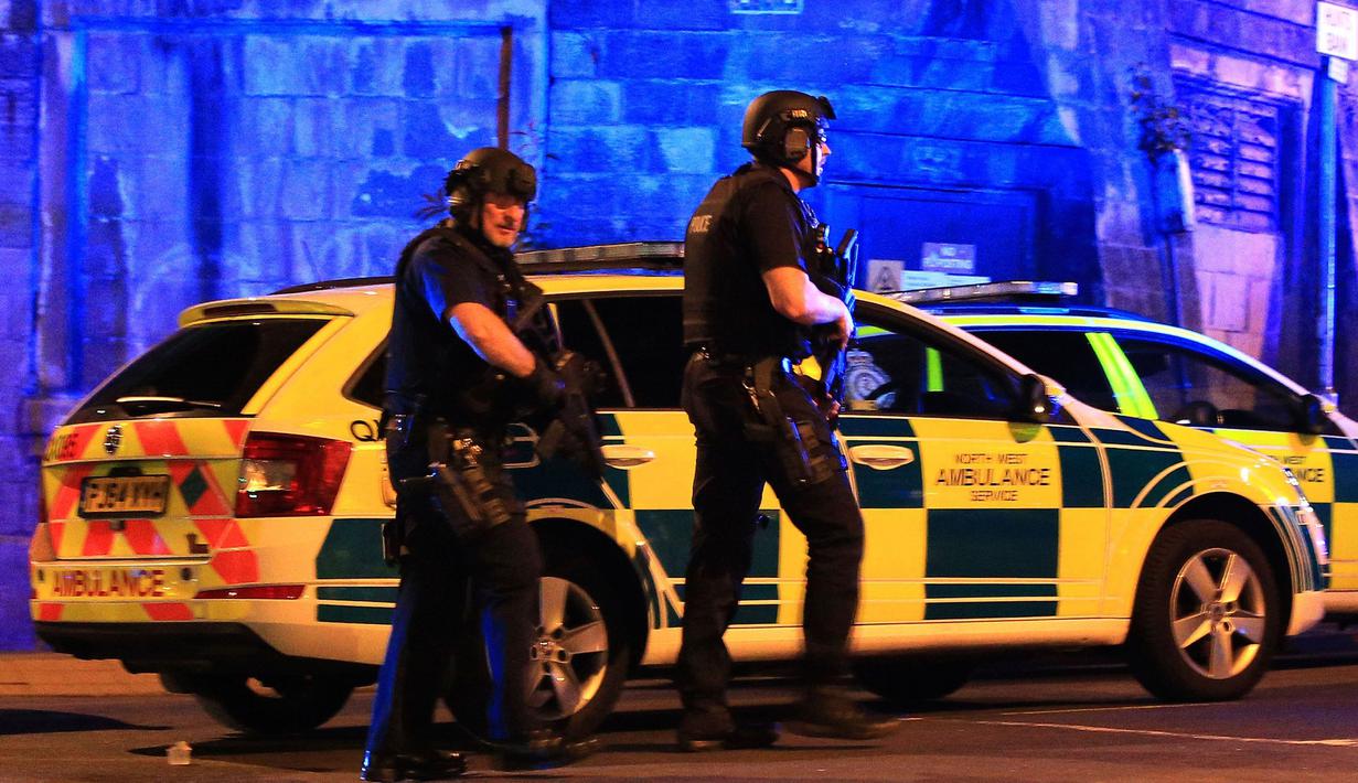 Polisi bersenjata mengamankan lokasi ledakan usai konser penyanyi Ariana Grande di Manchester Arena, Inggris, Senin (22/5). Ledakan yang menewaskan 19 orang itu terjadi sesaat setelah Ariana Grande selesai mengadakan pertunjukan. (Peter Byrne/PA via AP)