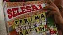 Pedagang membaca tabloid Bola di Terminal Kampung Melayu, Jakarta, Jumat (26/10). Dalam perjalanannya, Bola memberi warna pada dinamika olahraga nasional dan internasional. (Merdeka.com/Imam Buhori)