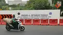 Pengendara sepeda motor melintas dekat proyek pembangunan jalur kereta Light Rail Transit (LRT) di Jalan Setiabudi Tengah, Jakarta, Senin (17/6/2019). Jalan Setiabudi Tengah ditutup mulai 17 Juni 2019 hingga 20 Februari 2020. (Liputan6.com/Herman Zakharia)