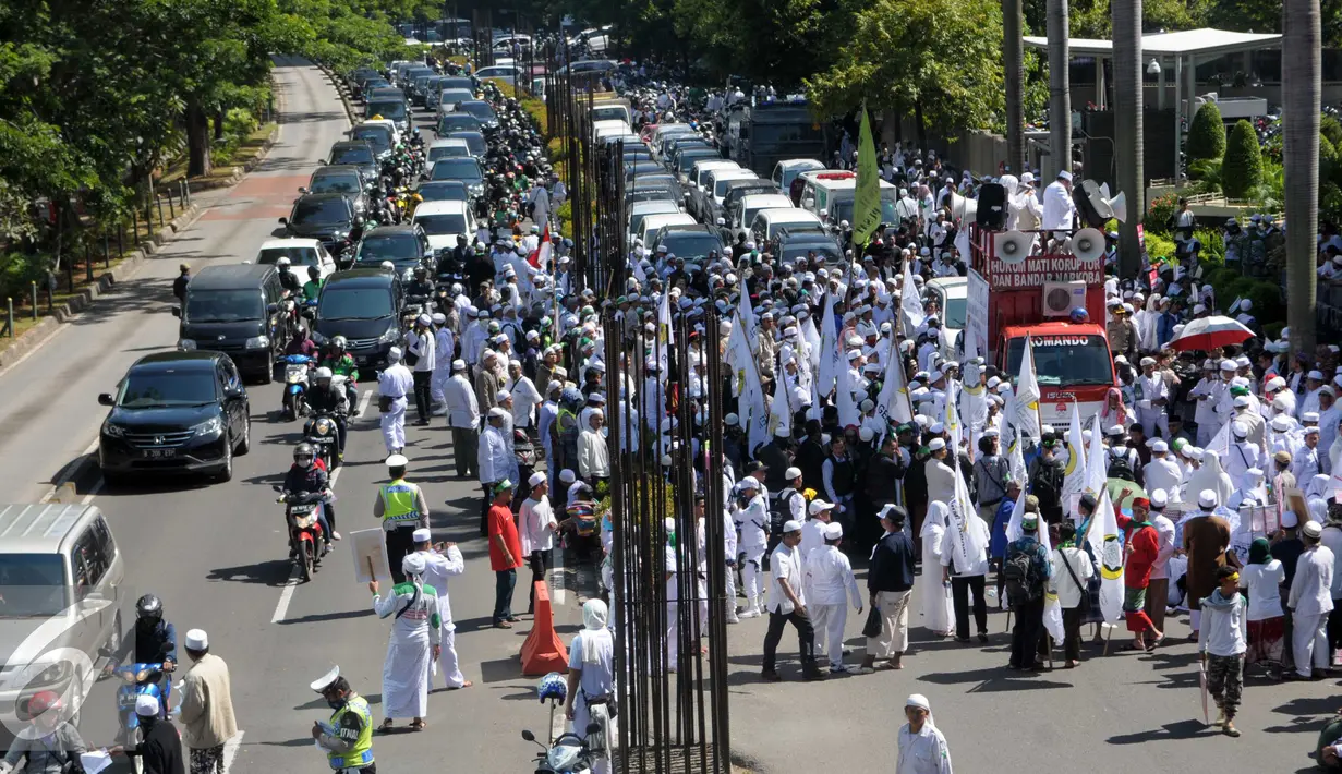 Sejumlah Massa berjalan ke arah menteng dari kuningan saat mengelar aksi, Jakarta, Senin (4/4). Dalam Aksinya tersebut mendesak agar di periksannya Gubernur Jakarta, Ahok terkait Korupsi Rs Sumber waras. (Liputan6.com/Helmi Afandi)