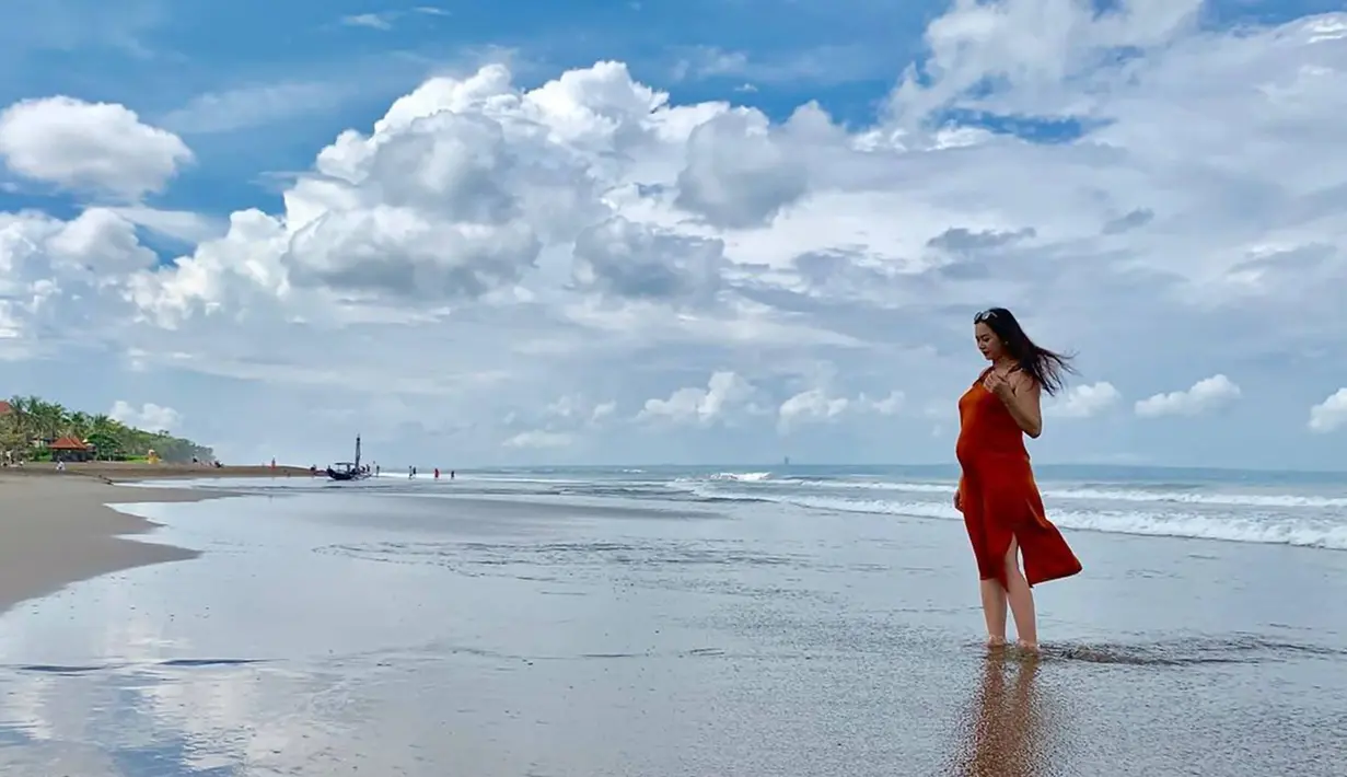 Liburan ke pantai saat mengandung Arabella juga menjadi salah satu liburannya kala itu. Dalam momen baby moon tersebut, Aura Kasih membagikan potretnya saat berada di tepi pantai mengenakan busana dress yang menawan. (Liputan6.com/IG/@aurakasih)