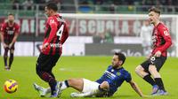 Pemain Inter Milan Hakan Calhanoglu berebut bola dengan pemain AC Milan Ismael Bennacer (kiri) dan Alexis Saelemaekers pada pertandingan leg pertama semifinal Coppa Italia di Stadion San Siro, Milan, Italia, 1 Maret 2022. Pertandingan berakhir imbang 0-0. (AP Photo/Antonio Calanni)