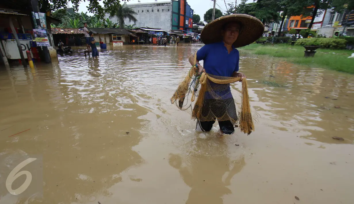 Warga membawa jaring untuk mencari ikan saat banjir di jalan Merpati Raya kota,Tangerang Selatan, Selasa (21/2). Intensitas curah hujan yang tinggi di sertai buruknya Drainase menyebabkan banjir 50-100 cm di kawasan tersebut. (Liputan6.com/Helmi Afandi)