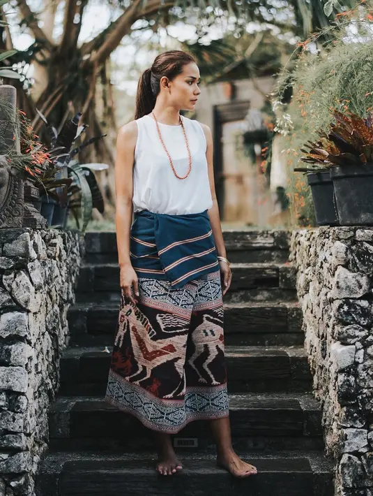 Begini inspirasi padu padan white sleeveless blouse dengan tenun ikat Pahikung dari Sumba yang dililit sebagai bawahan. Adik Sara Wijayanto ini tampil natural dan tetap elegan dengan ramput ponytail. Tak lupa ia menambahkan aksesoris simple seperti kalung.(Liputan6.com/IG/@adiniawrst)