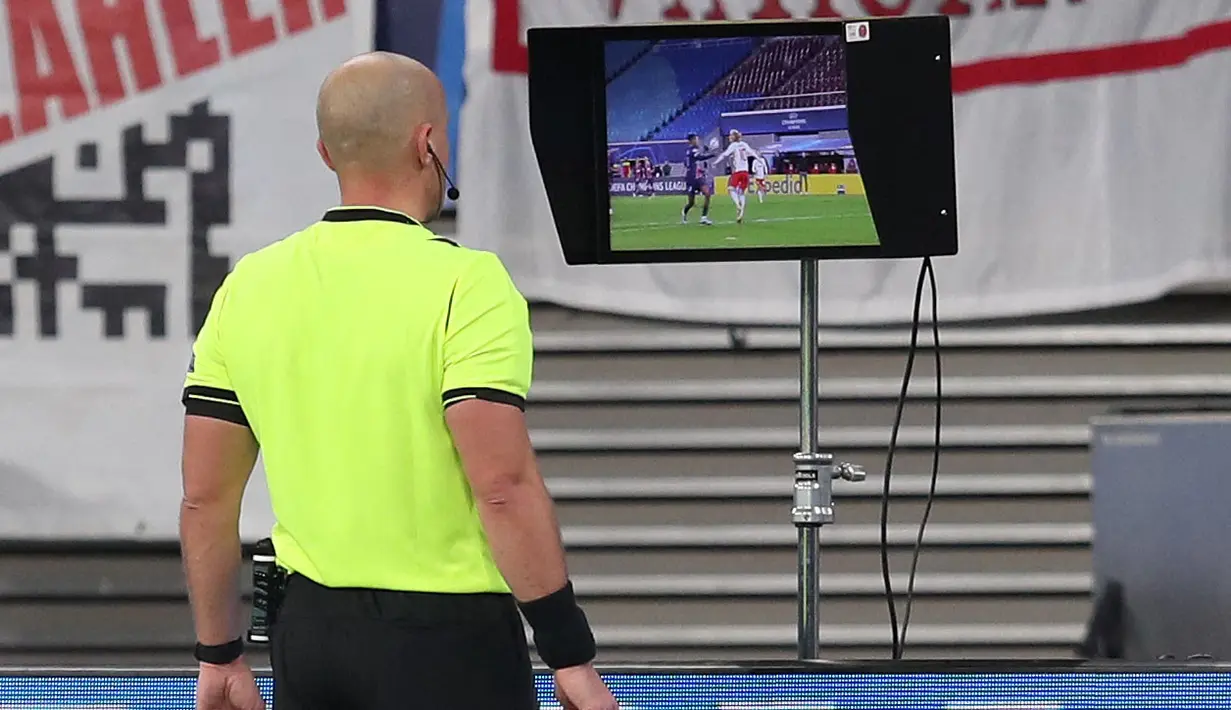 Wasit Szymon Marciniak memeriksa VAR sebelum memberikan penalti untuk RB Leipzig pada laga Grup H Liga Champions 2020/2021 antara RB Leipzig melawan Paris Saint-Germain di Redbull Arena, Leipzig, 4 November 2020. (AFP/Ronny Hartmann)