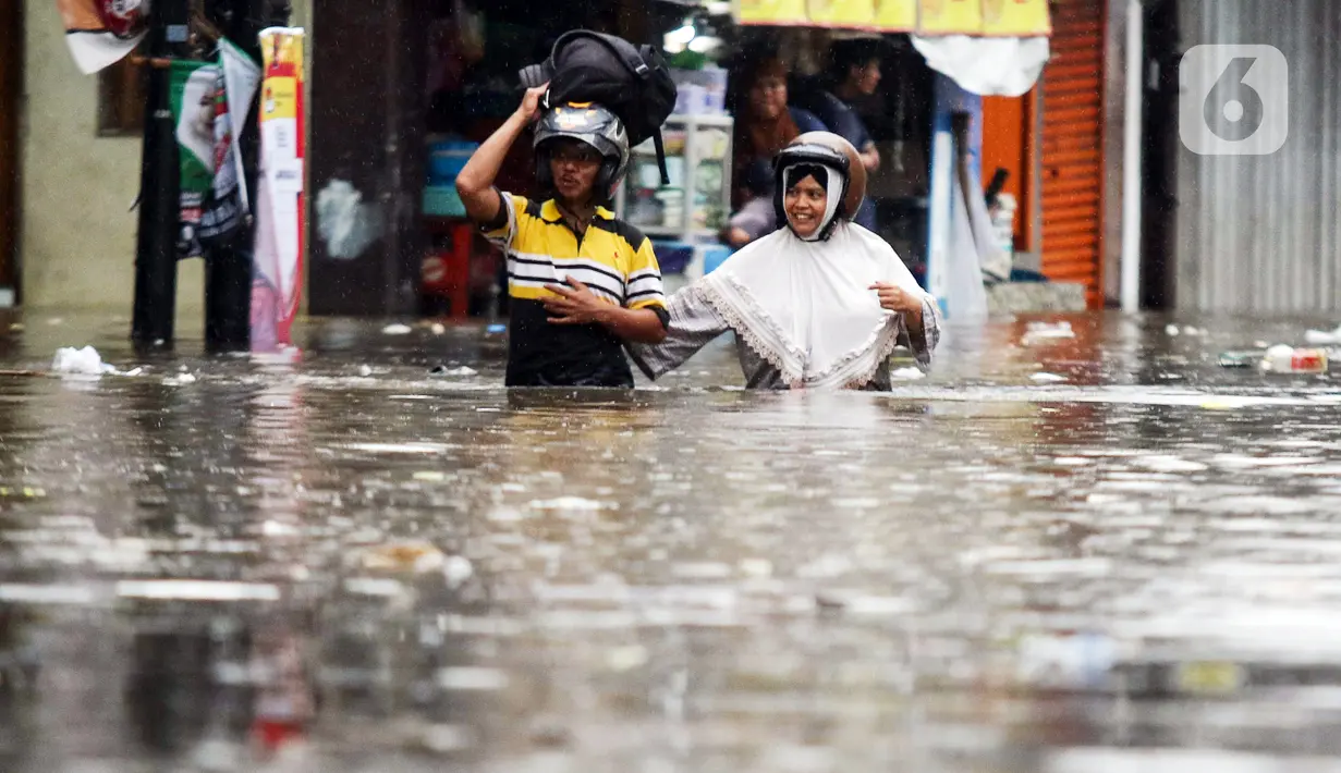 Warga melintasi genangan banjir yang melanda kawasan Kemang Utara, Jakarta, Kamis (4/1/2024). (Liputan6.com/Herman Zakharia)