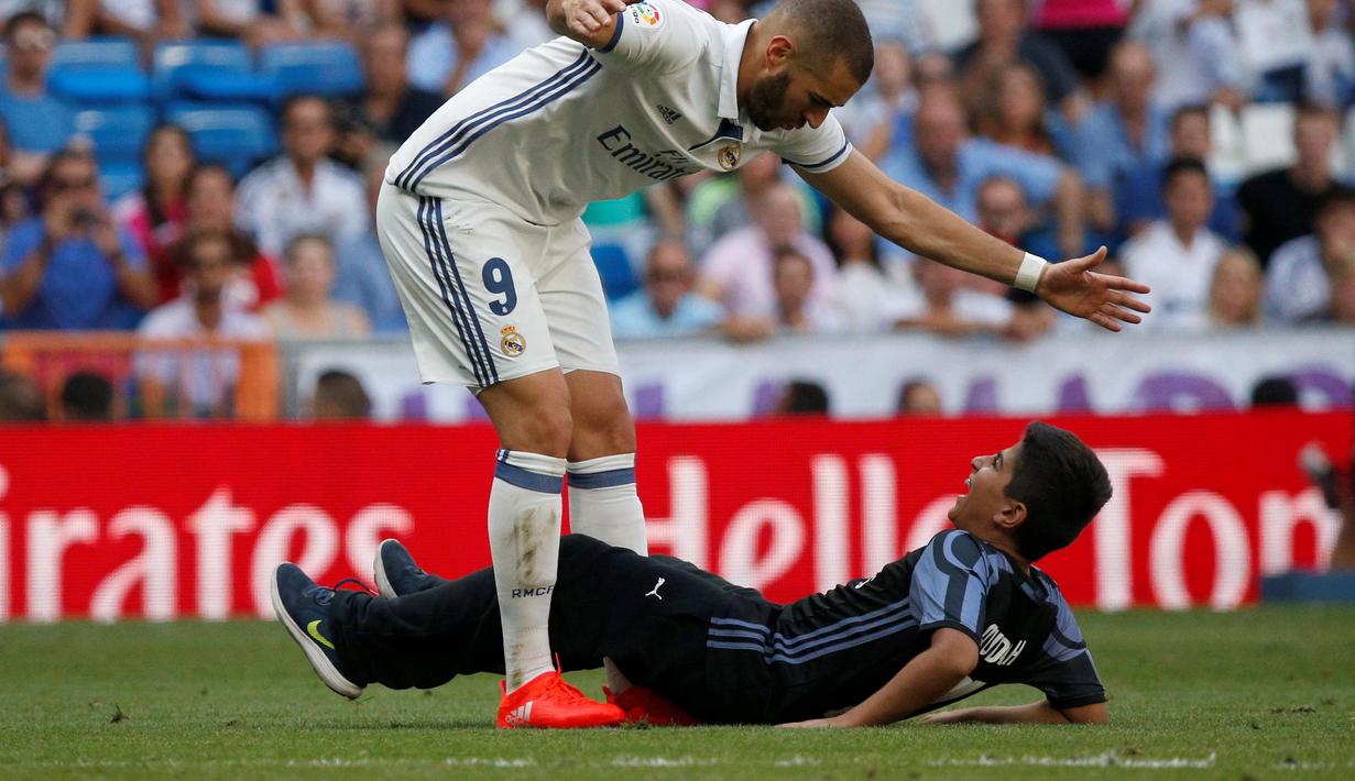 Pemain Real Madrid, Karim Benzema, bereaksi saat ingin dipeluk seorang pengemar pada laga melawan Osasuna di Stadion Santiago Bernabeu, Madrid, Spanyol, Sabtu (10/09/2016) malam WIB. Real Madrid menaklukkan Osasuna, 5-2. (Reuters/Juan Medina)