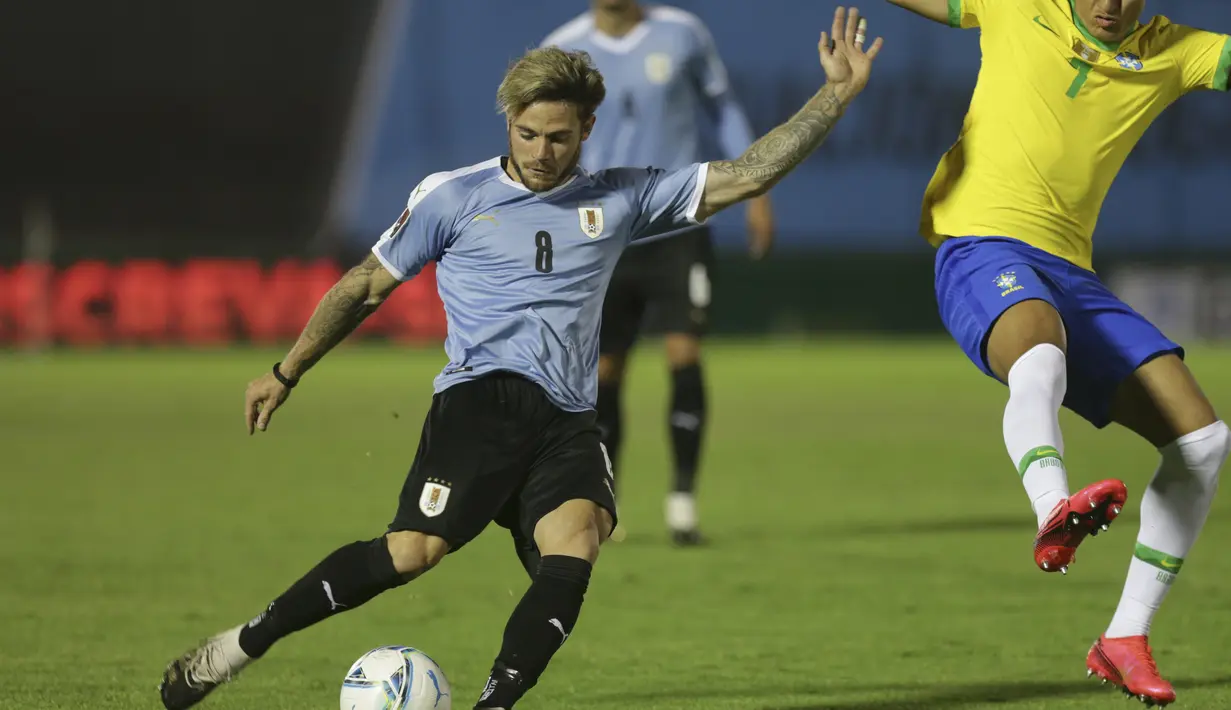 Gelandang Uruguay, Nahitan Nandez menembak bola dari kawalan gelandang Brasil, Richarlison pada pertandingan keempat kualifikasi Piala Dunia 2022 zona CONMEBOL di Estadio Centenario, Montevideo, Selasa (17/11/2020). Brasil menang atas Uruguay 2-0. (AP Photo/Matilde Campodonico, Pool)