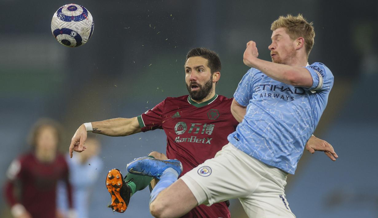 Gelandang Manchester City, Kevin De Bruyne (kanan) berebut bola dengan gelandang Wolverhampton Wanderers, Joao Moutinho dalam laga lanjutan Liga Inggris 2020/21 pekan ke-27 di Etihad Stadium, Selasa (2/3/2021). Manchester City menang 4-1 atas Wolverhampton. (AP/Carl Recine/Pool)