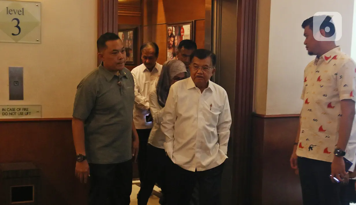 Mantan Wakil Presiden, yang juga Ketua Umum Palang Merah Indonesia (PMI) Jusuf Kalla saat akan menyaksikan jajaran foto kegiatan anggota PMI saat Musyawarah Nasional XXI PMI, di Jakarta, Selasa (17/12/2019). Jusuf Kalla kembali memimpin PMI untuk periode 2019-2024. (Liputan6.com/Herman Zakharia)