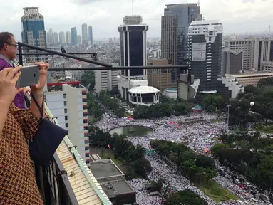 Menteri BUMN, Rini Soemarno mengabadikan gambar demo 2 Desember di atas gedung BUMN, Jakarta, Rabu (2/12). Demo 2 Desember digelar sebagai lanjutan dari aksi 4 November 2016. (Liputan6.com/Ferbian Pradolo)