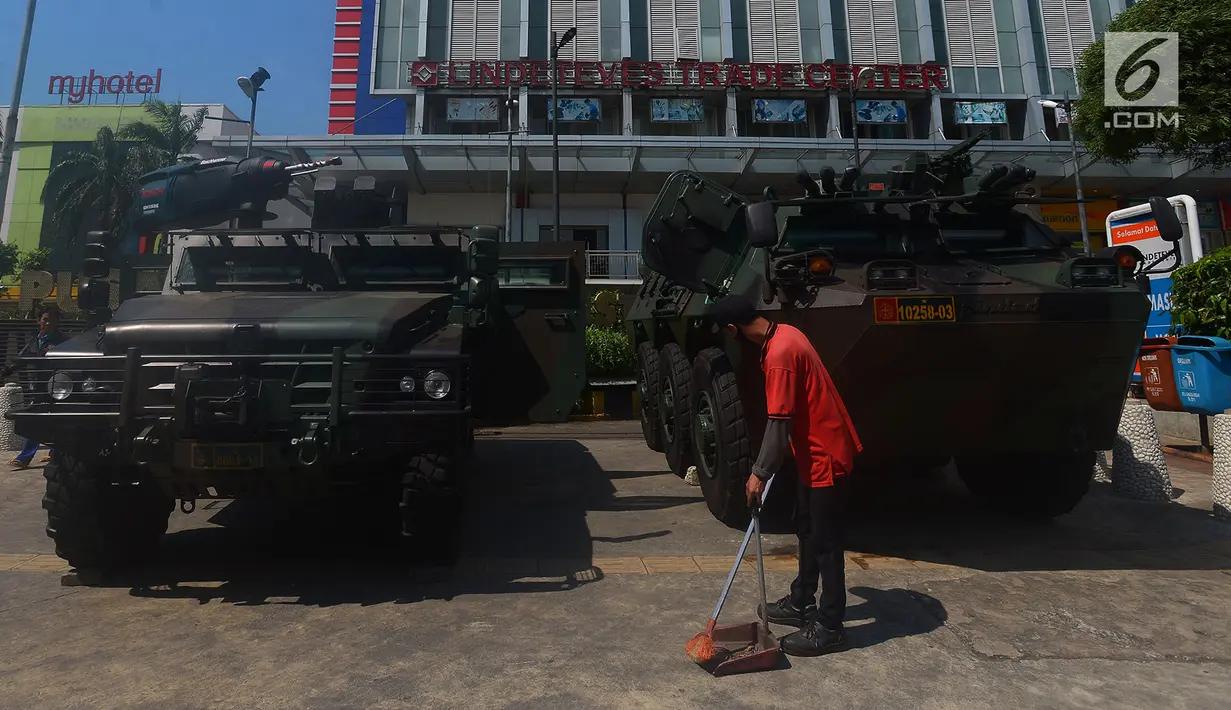 Petugas kebersihan menyapu di depan kendaraan lapis baja TNI di pertokoan Glodok, Jakarta, Jumat (11/5). Pengamanan ketat dilakukan guna antisipasi peristiwa yang tidak diinginkan terkait Aksi Bela Palestina di Monas. (Merdeka.com/Imam Buhori)