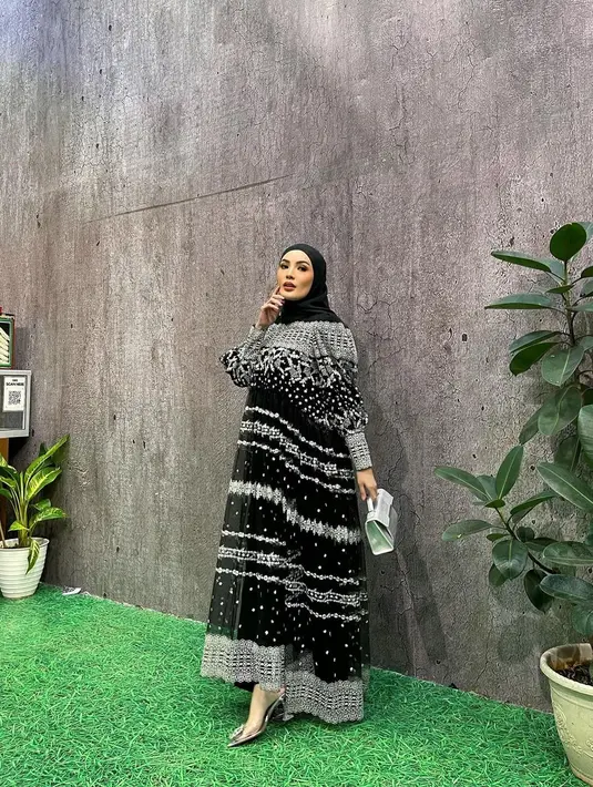 Dress dari @khanaan.official itu dipadukannya bersama pashmina warna hitam dan hand bag warna putih. [@nindyayunda]