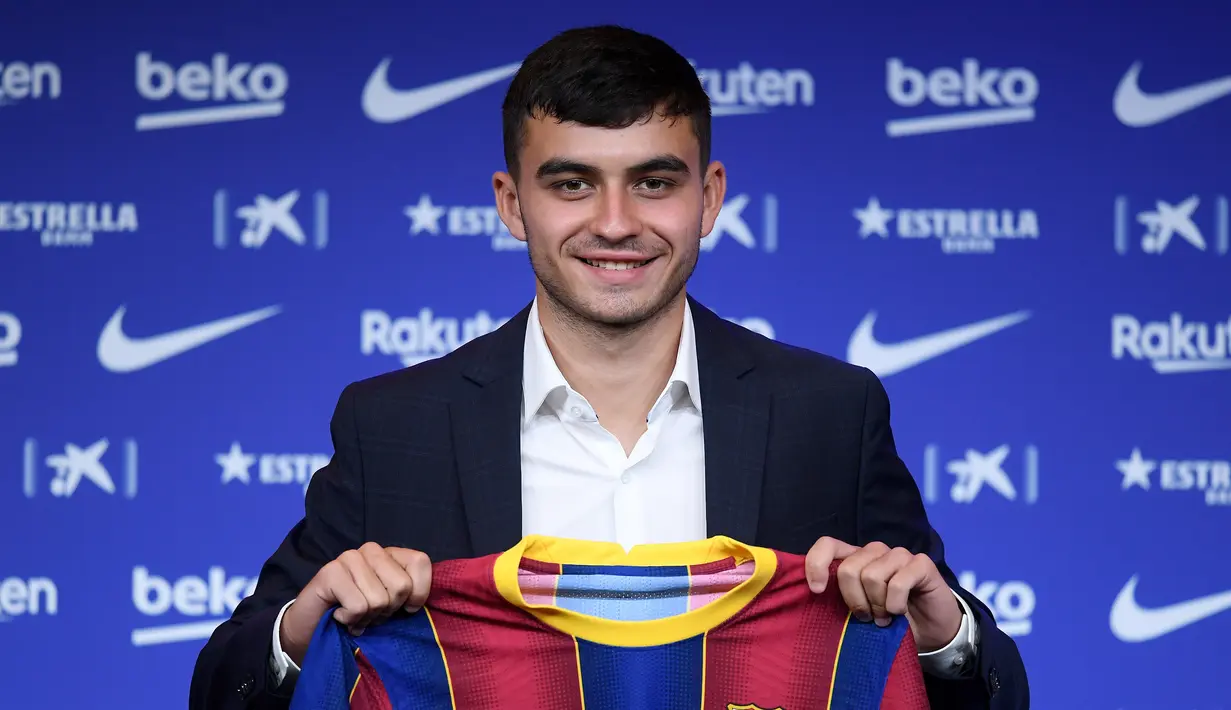 Penyerang Pedri berpose dengan jersey klub barunya Barcelona selama presentasi resmi di stadion Camp Nou di Barcelona (20/8/2020). Barcelona mengontrak Pedri dari Las Palmas. (AFP/Josep Lago)