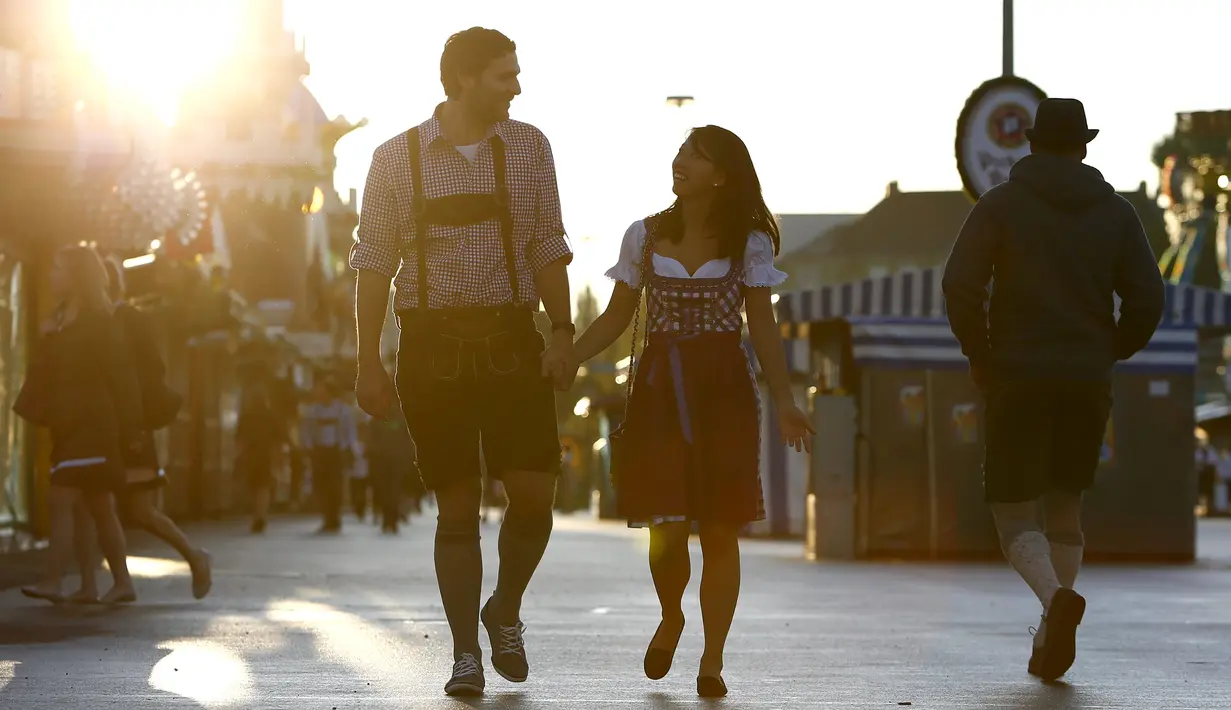 Pengunjung dengan pakaian tradisional Bavaria memasuki tenda saat pembukaan 182 Oktoberfest di Munich, Jerman (19/9/2015.) Jutaan peminum bir akan datang ke ibukota Bavaria selama dua minggu untuk 182th Oktoberfest. (REUTERS/Michaela Rehle)