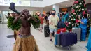 Penari tradisional dengan rok rumput menyambut wisatawan di Nadi, Fiji, Rabu (1/12/2021). Fiji membuka perbatasannya untuk pelancong internasional pertama kalinya sejak pandemi Covid-19 melanda dunia dan menghancurkan ekonominya yang bergantung pada pariwisata. (Leon LORD/AFP)