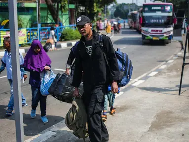 Pemudik membawa barang bawaan setibanya di Terminal Bus Kampung Rambutan, Jakarta Timur, Minggu (9/6/2019). Jumlah penumpang yang memasuki terminal Kampung Rambutan dalam arus balik Lebaran 2019 diperkirakan bakal memuncak pada Minggu (9/6) ini. (Liputan6.com/Faizal Fanani)