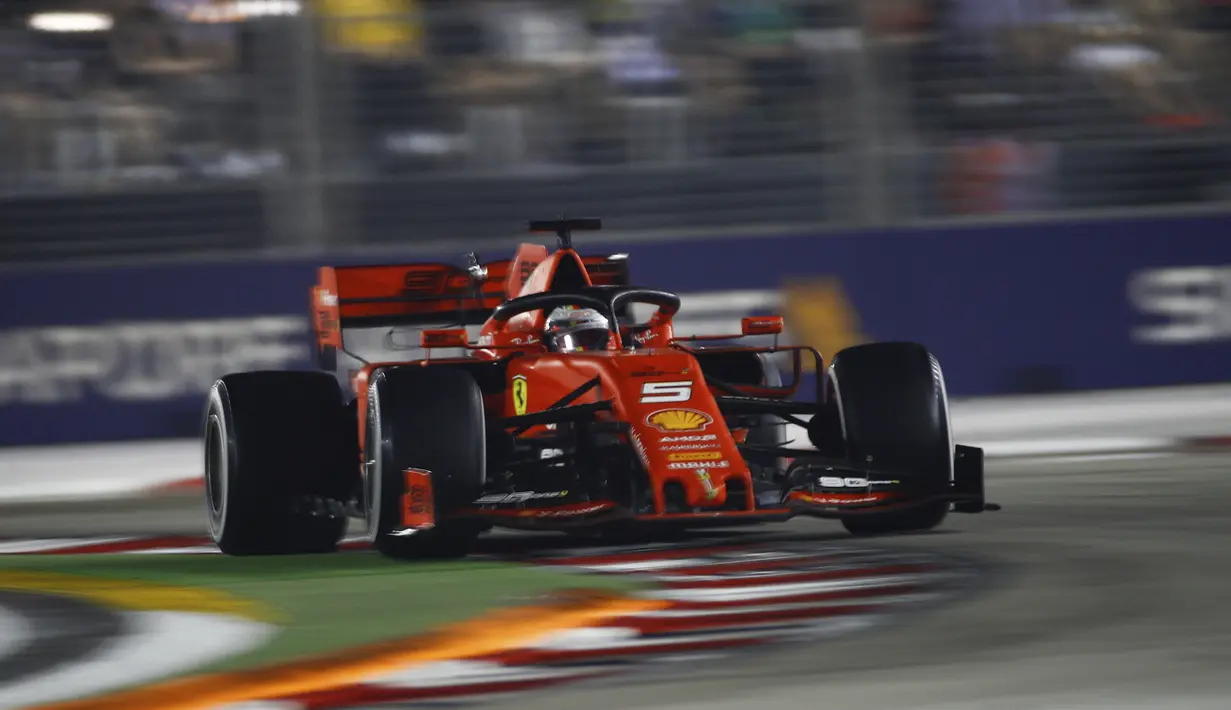 Pembalap Ferrari Sebastian Vettel memacu mobilnya dalam balapan Formula Satu (F1) Grand Prix Singapura di Sirkuit Jalan Marina Bay, Singapura (22/9/2019). Puncak klasemen sementara masih dipegang oleh Lewis Hamilton. (AP Photo/Eric To)