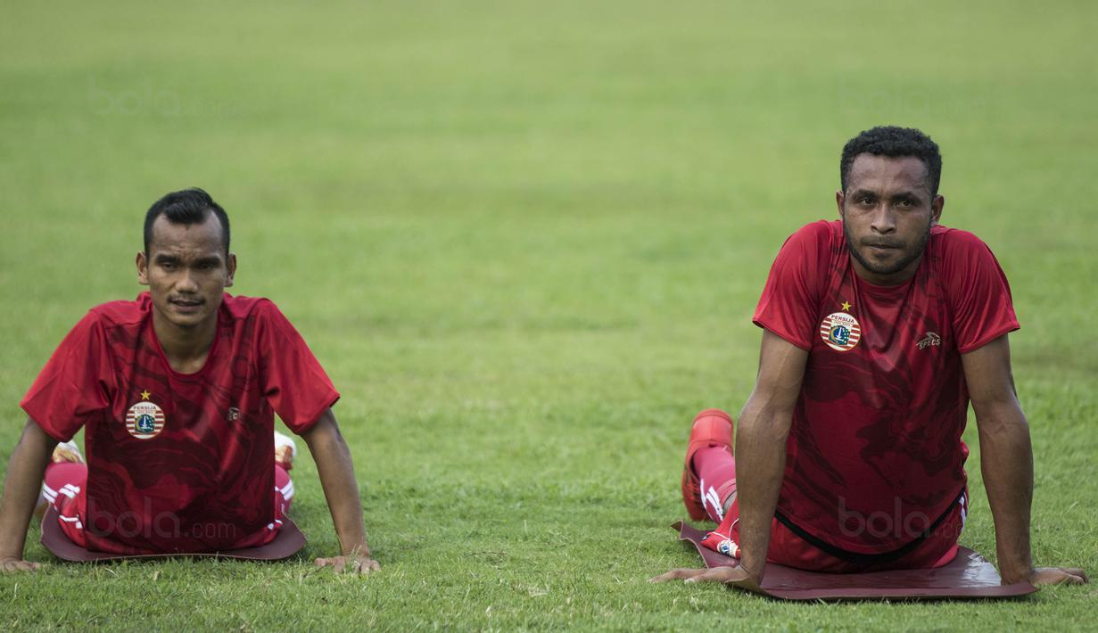 Gelandang anyar Persija, Arthur Bonai (kanan), melakukan pendinginan saat latihan perdana di Lapangan Sutasoma, Jakarta, Senin (18/12/2017). Arthur didatangkan Macan Kemayoran dari Persiwa. (Bola.com/Vitalis Yogi Trisna)