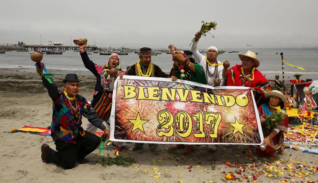 Sejumlah dukun asal Peru membentangkan poster prediksi ramalan jelang pergantian tahun di Pantai Agua Dulce di Lima, Peru, (29/12). Para dukun tersebut meramalkan tahun 2017. (Reuters/Mariana Bazo)
