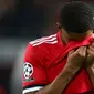 Striker Manchester United, Marcus Rashford mengusap jersey ke wajahnya sambil berjalan keluar lapangan usai laga leg kedua 16 besar Liga Champions di Old Trafford, Selasa (13/3). Manchester United menyerah 1-2 kepada tamunya Sevilla. (AP/Dave Thompson)