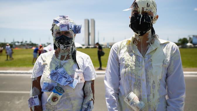 Demonstran ambil bagian dalam aksi protes terhadap Presiden Brasil Jair Bolsonaro dan penanganan pandemi virus corona di Brasilia, pada Minggu (31/1/2021). Di antara mereka bahkan banyak yang menuntut pengunduran diri atau pemakzulan Presiden Brasil Jair Bolsonaro. (Sergio LIMA/AFP)