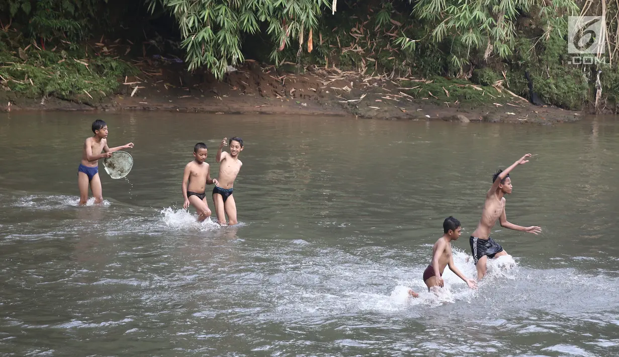 Anak-anak bermain air di aliran Sungai Ciliwung, Depok, Jawa Barat (30/5). Sungai Ciliwung kini menjadi tempat wisata alternative bagi masyarakat untuk bermain sekaligus menjaga kebersihan lingkungan. (Liputan6.com/Herman Zakharia)