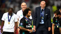 Zinedine Zidane dan asistennya David Bettoni merayakan di podium setelah memenangkan pertandingan melawan MU di Arena Philip II di Skopje (8/8). Gelar ini menjadi yang keenam bagi Zidane sebagai pelatih Los Blancos. (AFP Photo/Dimitar Dikloff)