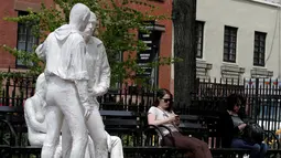 Dua perempuan duduk di dekat patung yang disebut 'Gay Liberation' di Christopher Park, Greenwich Village New York City, AS, (9/5). Patung ini dibuat untuk memperingati peristiwa pembebasan gay dan lesbian di Amerika Serikat. (REUTERS / Brendan McDermid)