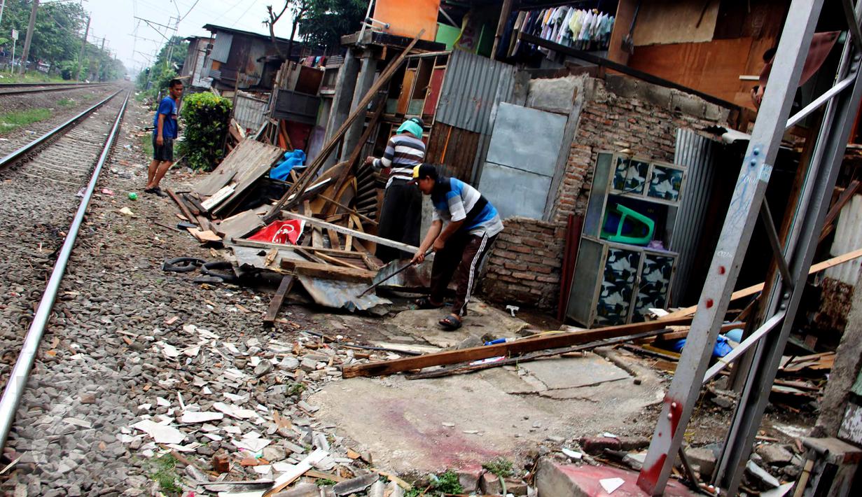 Warga membongkar bangunan rumahnya yang terletak di pinggir rel kereta api di kawasan Kelurahan Rawajati, Pancoran, Jakarta, Rabu (10/6/2015). Warga rela membongkar sendiri rumahnya karena bermukim di lahan milik PT KAI. (Liputan6.com/Helmi Afandi)