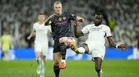 Striker Manchester City, Erling Haaland (kiri) berebut bola dengan bek Real Madrid, Antonio Rudiger pada laga leg pertama babak perempatfinal Liga Champions 2023/2024 di Santiago Bernabeu Stadium, Selasa (9/4/2024) malam. (AP Photo/Manu Fernandez)