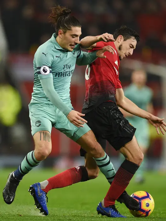 Bek Arsenal, Hector Bellerin berebut bola dengan bek Manchester United, Matteo Darmian selama pertandingan lanjutan Liga Inggris di stadion Old Trafford (5/12). MU bermain imbang 2-2 atas Arsenal. (AFP Photo/Oli Scarff)