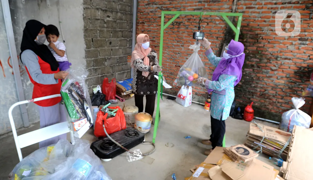 Pekerja menimbang sampah rumah tangga di bank sampah Gepe Two, Perumahan Griya Pamulang II, Tangerang Selatan, Banten, Rabu (23/12/2020). Bank sampah ini bertujuan untuk mengurangi volume sampah rumah tangga ke TPA dan menambah perekonomian keluarga melalui tabungan sampah. (merdeka.com/Arie Basuki)