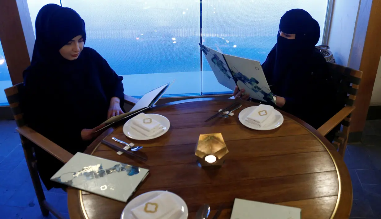 Dua wanita berhijab memilih menu di sebuah kafe di Riyadh, Arab Saudi (6/10). (REUTERS/Faisal Al Nasser)