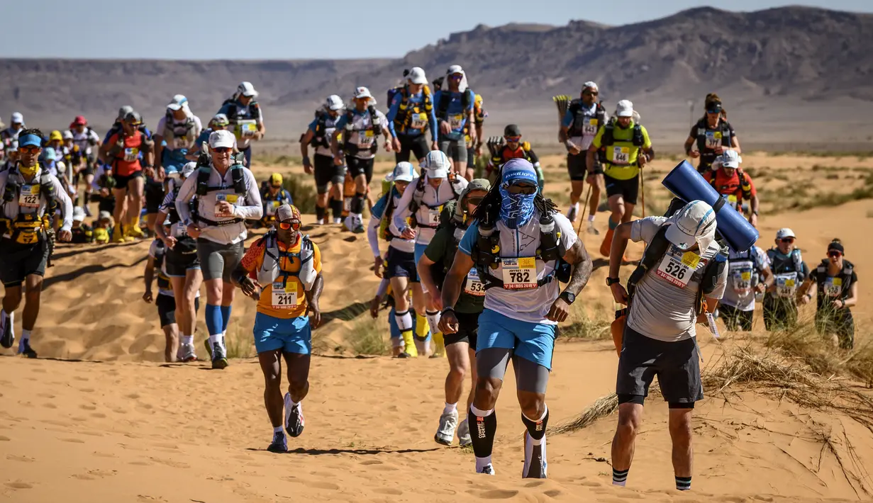 Para peserta bersaing dalam lomba lari Marathon des Sables ke-34 tahap kedua di Gurun Sahara, Maroko, Minggu (7/4). Lomba yang diselenggarakan sejak tahun 1986 ini digelar di Gurun Sahara pada bulan April. (JEAN-PHILIPPE KSIAZEK/AFP)