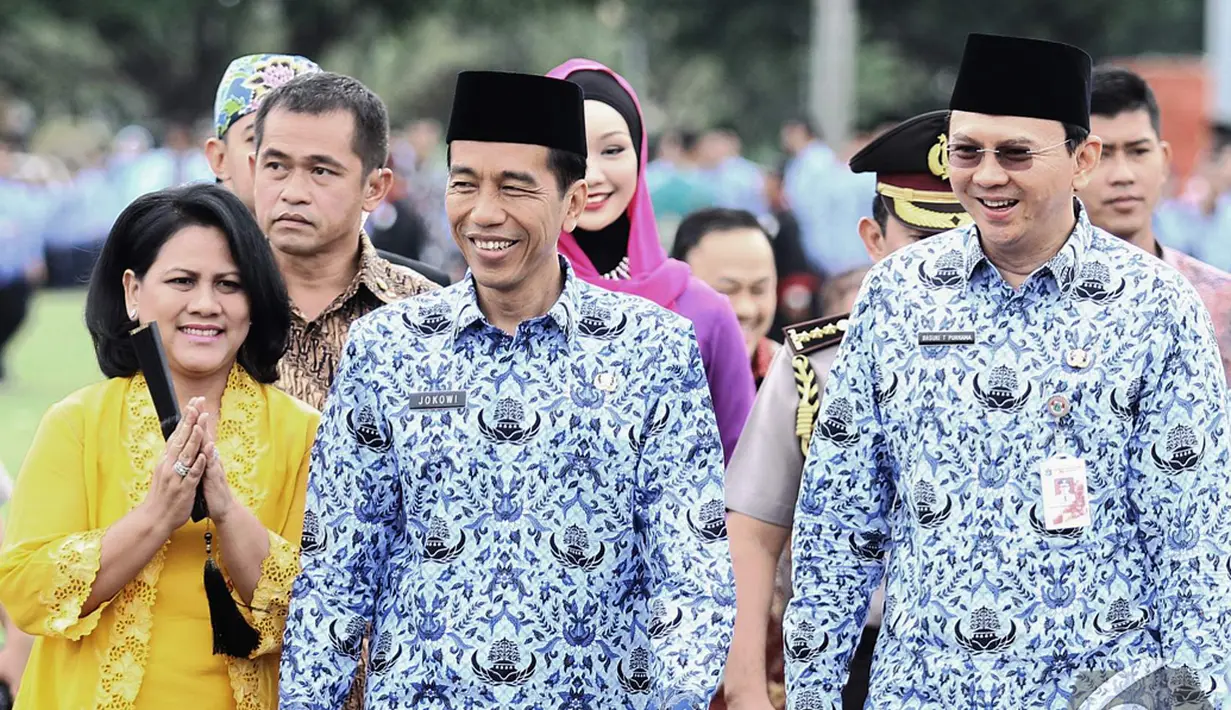 Iriana, Jokowi dan Ahok berjalan bersama saat menghadiri Upacara HUT Korps Pegawai Republik Indonesia (Korpri) ke-43 di halaman Monumen Nasional (Monas), Jakarta, Senin (1/12/2014). (Liputan6.com/Faizal Fanani)