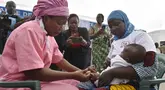 Seorang petugas kesehatan memberikan vaksin malaria Oxford-Serum R21 kepada seorang anak di Abidjan, Pantai Gading, Senin (15/7/2024).  (Foto AP/Diomande Ble Pirang)