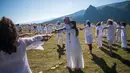 Anggota gerakan keagamaan internasional White Brotherhood menari di puncak Gunung Rila, Bulgaria, Senin (19/8/2019). Para peserta menari selama lebih dari satu jam di bawah suara nyanyian dan biola. (NIKOLAY DOYCHINOV/AFP)