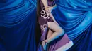 Di momen lainnya, Aura Kasih mengenakan outfit bersiluet cheongsam berwarna ungu. Outfitnya kali ini tanpa lengan dengan kerah tinggi dan high slit yang kembali memperlihatkan kaki jenjangnya. [Foto: Instagram/fxedbert]