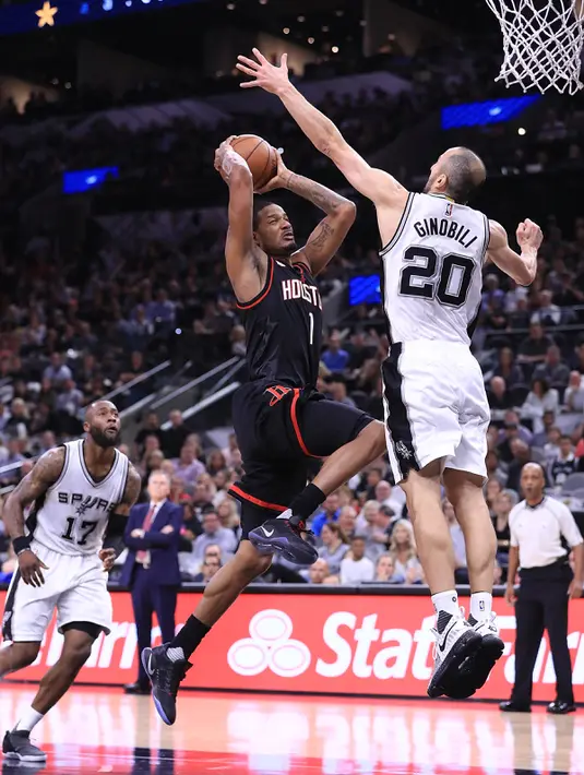 Aksi Pemain Rockets, Trevor Ariza (1) melewati pemain Spurs, Manu Ginobili pada gim kelima semifinal wilayah barat Playoffs NBA 2017 di AT&T Center, San Antonio, Texas (9/5). Gim keenam akan gantian digelar di Houston.  (Ronald Martinez/Getty Images/AFP)