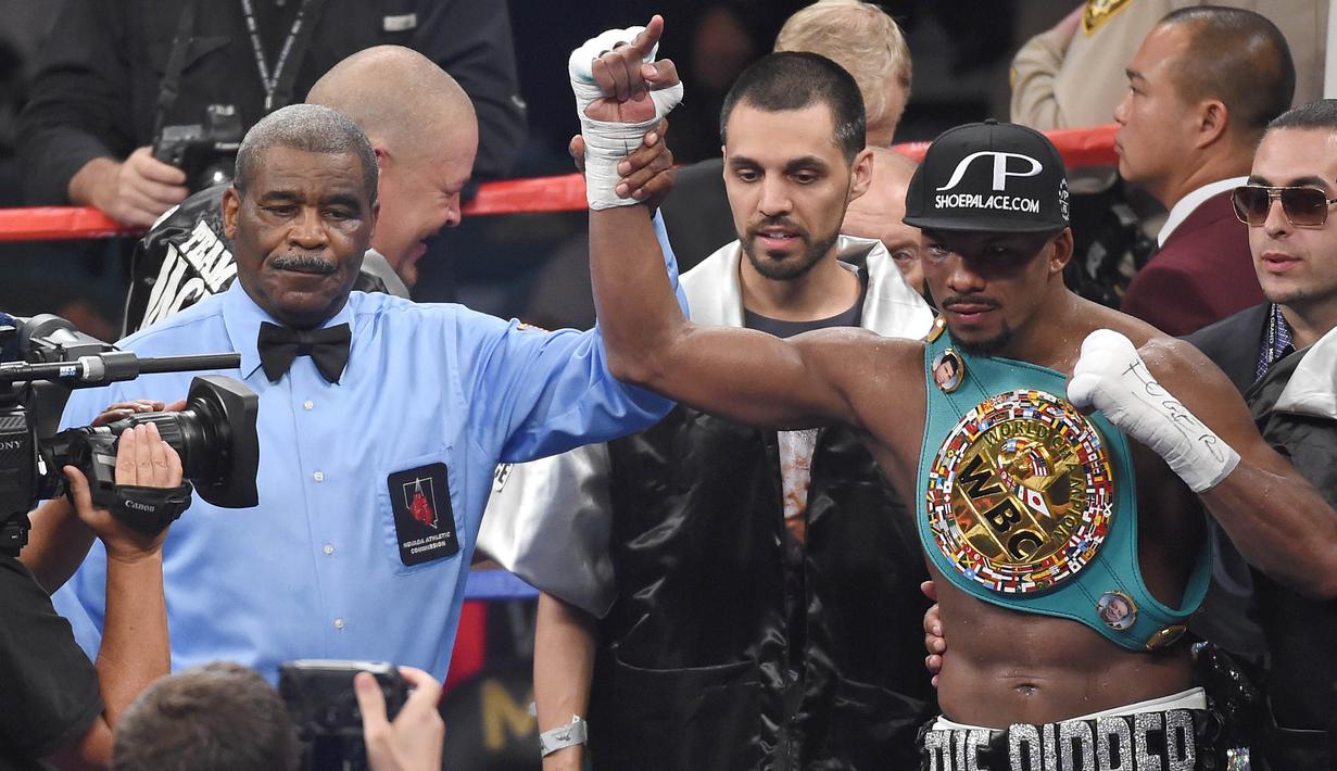 Wasit Robert Byrd mengangkat tangan Badou Jack's usai berhasil mengalahkan George Groves di Las Vegas, Sabtu (12/9/2015). Robert Byrd akan menjadi wasit yang memimpin laga tinju antara Floyd Mayweather dan Conor McGregor. (AFP/Ethan Miller)